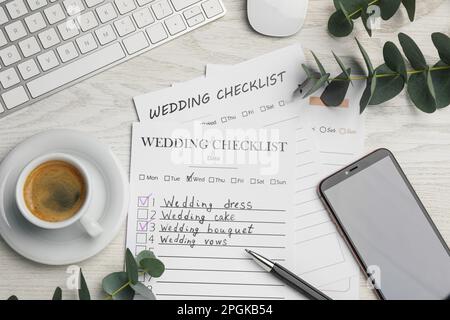 Composizione di posa piatta con liste di controllo per matrimoni su tavolo di legno bianco Foto Stock