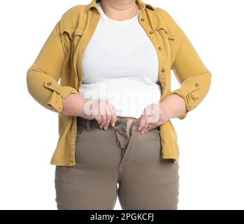 Donna sovrappeso cercando di buttare su pantaloni stretti su sfondo bianco, primo piano Foto Stock