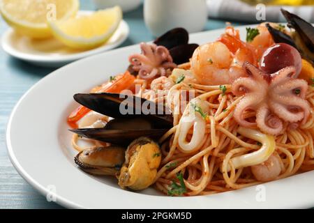 Deliziosi spaghetti con pesce servito sul tavolo, primo piano Foto Stock