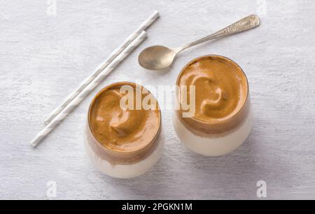 Due bicchieri con caffè Dalgona, cocktail freddo con schiuma di caffè montata, popolare bevanda di tendenza su sfondo chiaro, vista dall'alto Foto Stock
