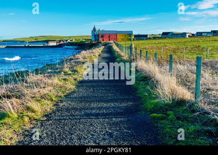 Il sentiero costiero e gli edifici di estensione dell'hotel presso il porto di John o' Groats, Caithness, Scozia, Regno Unito Foto Stock