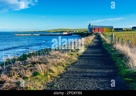 Il sentiero costiero e gli edifici di estensione dell'hotel presso il porto di John o' Groats, Caithness, Scozia, Regno Unito Foto Stock