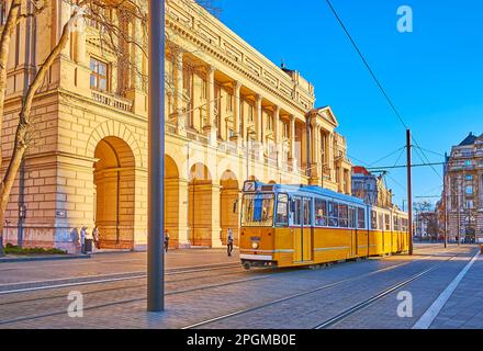 Il tram giallo vintage scorre su Piazza Lajos Kossuth contro la costruzione del Ministero dell'Agricoltura, Budapest, Ungheria Foto Stock