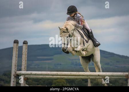 Una ragazza cavalca il cavallo sopra una delle recinzioni di salto. 41st Johnstown Coolgreany Gymkhana & Field giorno 2022. Wexford. Irlanda Foto Stock