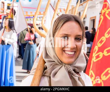 Huelva, Spagna - 18 marzo 2023: Bella giovane donna vestita da contadino con costume d'epoca e con una forchetta nella parata di scoperta medievale Foto Stock