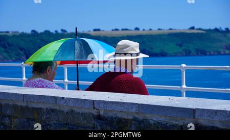 Plymouth, Devon, 06 luglio 2022; immagini dei giorni felici in pensione. Una coppia anziana ben vestita gode del sole e della vista dell'oceano. Foto Stock