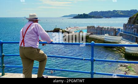 Plymouth, Devon, 06 luglio 2022; immagini dei giorni felici in pensione. Una coppia anziana ben vestita gode del sole e della vista dell'oceano. Foto Stock