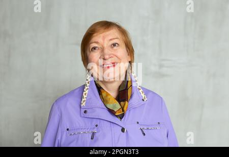 Donna anziana in piedi con fiducia vestita con abiti caldi con un sorriso pieno di allegria Foto Stock