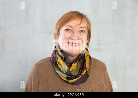 Donna anziana in piedi con fiducia vestita con abiti caldi con un sorriso pieno di allegria Foto Stock