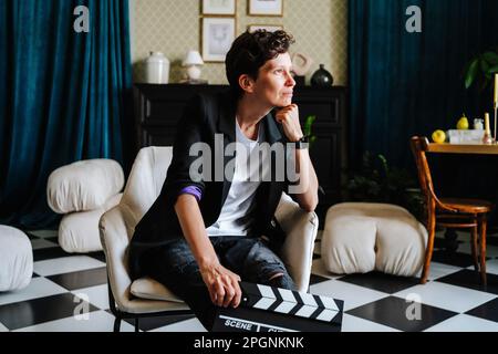 Regista premuroso seduto su sedia al set cinematografico Foto Stock