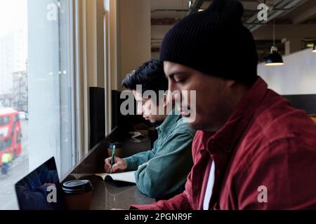 Freelance che lavorano insieme nel caffè Foto Stock