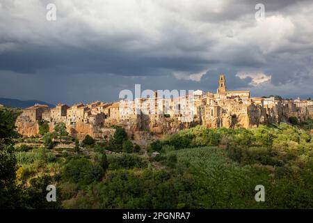 Italia, Toscana, Pitigliano, cielo nuvoloso sul bordo della vecchia città medievale in estate Foto Stock