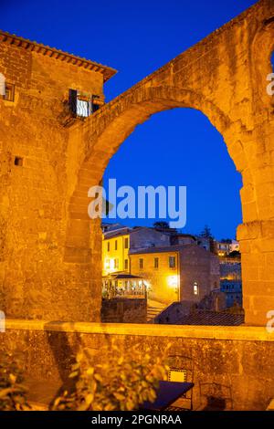 Italia, Toscana, Pitigliano, Arco nel centro storico medievale al tramonto Foto Stock