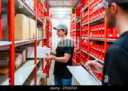 I lavoratori del magazzino che prendono l'inventario in fabbrica Foto Stock