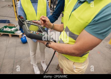 Ingegneri che detengono il controller in fabbrica Foto Stock