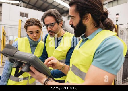 Ingegneri che utilizzano il controller in una fabbrica di robotica Foto Stock