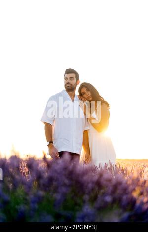 Uomo e donna retroilluminati in piedi in un campo di lavanda Foto Stock