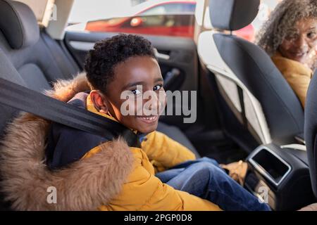 Felice ragazzo seduto con nonna in macchina Foto Stock
