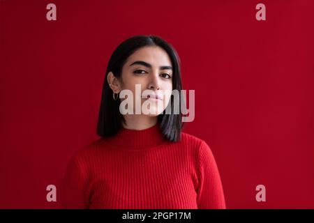 Giovane donna fiduciosa su sfondo rosso Foto Stock