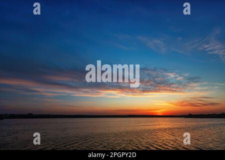 Un tranquillo Lago Blu con uno splendido cielo colorato Foto Stock