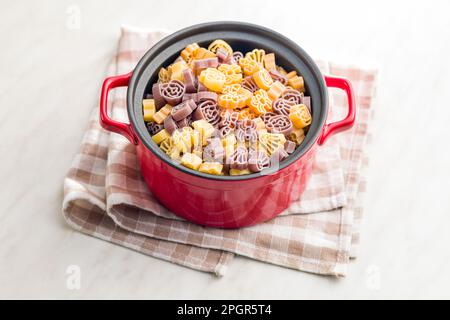 Pasta di varie forme spaventose. Pasta di Halloween cruda in pentola. Foto Stock