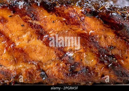 Texture di filetto fritto di maiale glassato, primo piano. Costolette di maiale alla griglia. Foto Stock