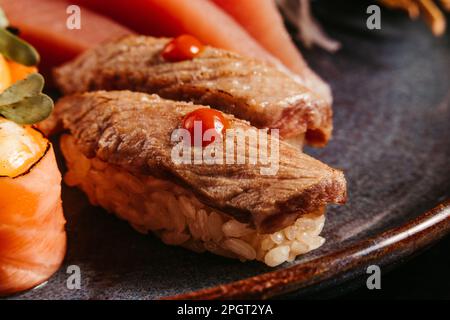 Un'immagine di primo piano di un sushi roll preparato di recente, con riso bianco e pezzi di carne cotta Foto Stock