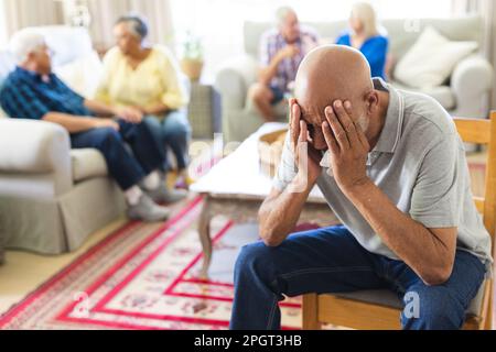 Gruppo di amici anziani emozionali e diversi in soggiorno durante la sessione di terapia di gruppo. Stile di vita, amicizia e supporto senior. Foto Stock