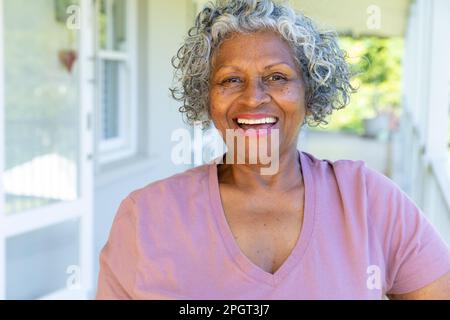 Primo piano ritratto di afroamericana donna anziana con capelli corti grigi ridere allegramente a casa. Copia spazio, inalterato, lifestyle, felice, pensirremen Foto Stock