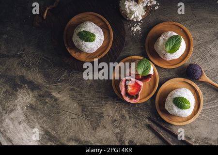 mochi giapponese o torta di riso ripiena di fagioli rossi e fragole, foglie di menta sulla parte superiore. Torta di riso tradizionale giapponese. Foto Stock