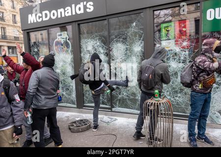 Rioter francese che infrange la finestra di un ristorante McDonald's, durante una protesta a Parigi, Francia Foto Stock