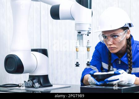 studente di ingegneria di macchine automatiche studia e controlla la macchina robot braccio di controllo in università o officina di fabbrica. tecnologia ai robotica nuova i Foto Stock