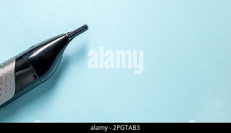 Vista dall'alto del rifinitore per naso e orecchie isolato su sfondo blu Foto Stock