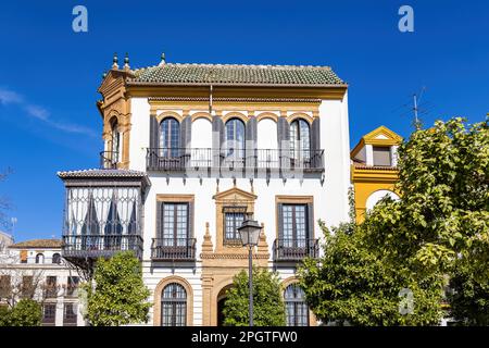 Bella vecchia casa con balconi in ferro battuto, grandi finestre e tegole colorate, nel quartiere di Santa Cruz del centro storico di Sevill Foto Stock