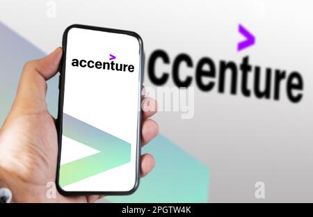 New York, Stati Uniti, marzo 2023: Tenere in mano un telefono con il logo Accenture visualizzato sullo schermo. Accenture è una multinazionale che si occupa di busin Foto Stock