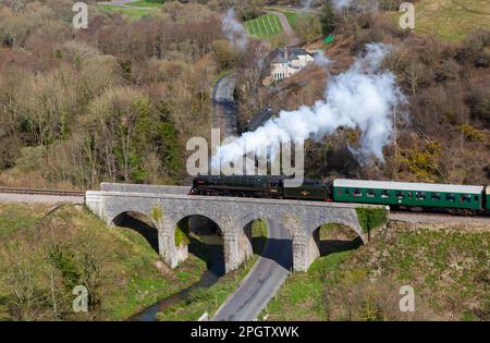 Corfe Castle, Dorset, Regno Unito. 24th marzo 2023. Nel febbraio 1952, la locomotiva a vapore della British Railways Standard Class n. 70000 “Britannia” ebbe il triste onore di trasportare il treno funebre di Re Giorgio VI, da King’s Lynn a Norfolk a Londra. Oggi la storica locomotiva passa attraverso il Castello di Corfe in una giornata molto ventosa con intervalli di sole, come parte del galà primaverile di Swanage Railway che si svolge dal 24 al 26th marzo. Credit: Carolyn Jenkins/Alamy Live News Foto Stock