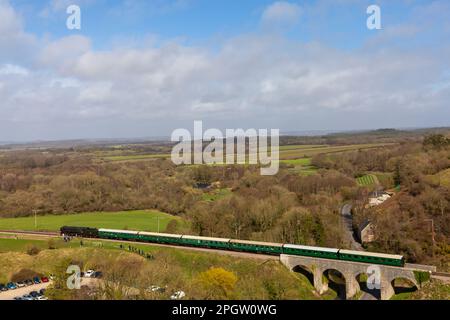 Corfe Castle, Dorset, Regno Unito. 24th marzo 2023. Nel febbraio 1952, la locomotiva a vapore della British Railways Standard Class n. 70000 “Britannia” ebbe il triste onore di trasportare il treno funebre di Re Giorgio VI, da King’s Lynn a Norfolk a Londra. Oggi la storica locomotiva passa attraverso il Castello di Corfe in una giornata molto ventosa con intervalli di sole, come parte del galà primaverile di Swanage Railway che si svolge dal 24 al 26th marzo. Credit: Carolyn Jenkins/Alamy Live News Foto Stock