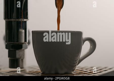 estrazione dell'espresso con portafiltro a beccuccio singolo dal primo piano della macchina da caffè, messa a fuoco poco profonda Foto Stock