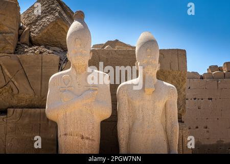 Statue di faraoni che tengono croci di ankh in entrambe le mani Foto Stock