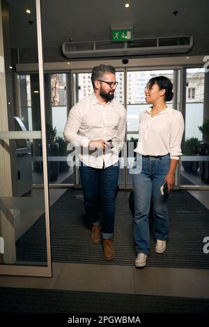 Giovane donna sorridente e la sua compagna in arrivo in albergo Foto Stock