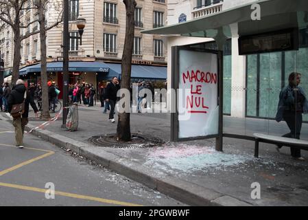 Un rifugio di autobus di una fermata nel centro di Parigi con le sue finestre rotte e il messaggio 'Macron le Null' visto durante uno sciopero generale sull'aumento dell'età pensionabile. Il nono giorno di sciopero contro la nuova riforma pensionistica del governo di Macron è stato segnato da molti scontri tra la polizia e i manifestanti. Dopo che Elisabeth Borne (primo ministro francese) invocò l'articolo 49,3 della Costituzione francese per imporre la nuova legge, migliaia di persone presero di nuovo le strade di Parigi in occasione di una manifestazione iniziata a Place de la Bastille. Foto Stock