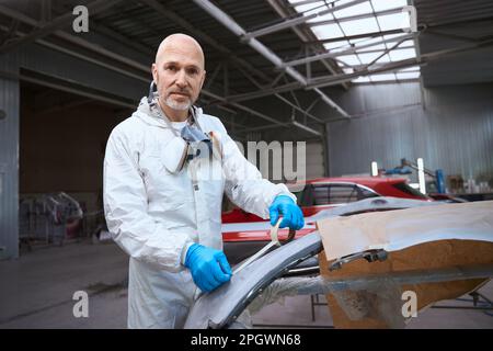 Il pittore prepara una parte della carrozzeria per il lavoro Foto Stock