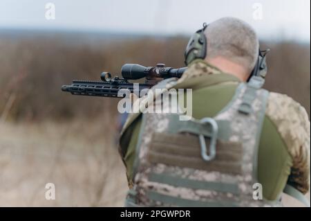 Un soldato militare dell'esercito sta sparando una mitragliatrice. Tiro e armi. Foto Stock