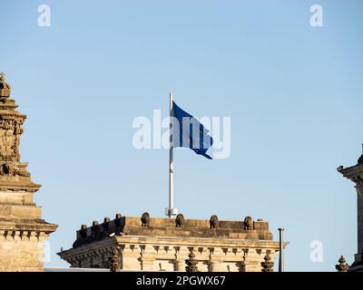 Bandiera dell'UE sul Reichstag a Berlino. Primo piano del simbolo dell'Unione europea in Germania. Il cielo sullo sfondo è chiaro e blu. Foto Stock