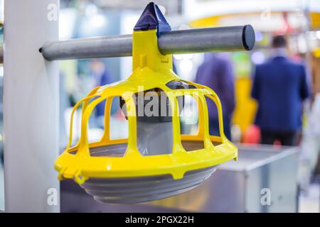 Alimentatore automatico di pollo giallo in plastica per allevamento di pollame in mostra: Primo piano Foto Stock