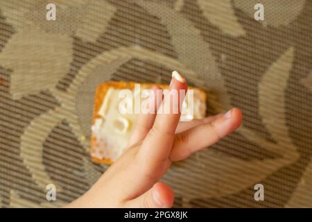 mano per bambini e biscotti con burro sul tavolo Foto Stock