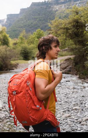 Uomo con zaino facendo un'escursione in una zona verde di montagna dei Paesi Baschi. Foto Stock