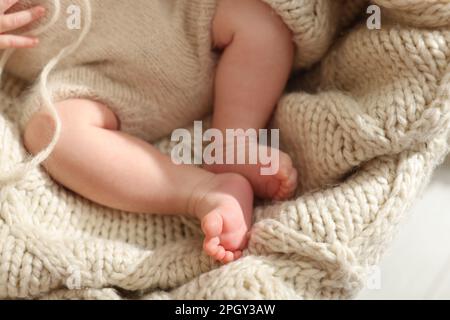 Adorabile neonato su plaid a maglia, primo piano Foto Stock