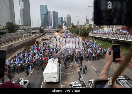 Tel Aviv, Israele. 23rd Mar, 2023. I cannoni d'acqua della polizia israeliana spruzzano i manifestanti contro la riforma legale che ha bloccato l'autostrada Ayalon durante la manifestazione. Migliaia di manifestanti contro la revisione legale hanno bloccato l'autostrada Ayalon di Tel Aviv. La polizia ha usato cannoni ad acqua per disperderli. Credit: SOPA Images Limited/Alamy Live News Foto Stock