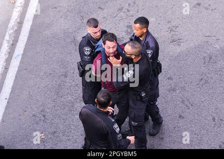 Tel Aviv, Israele. 23rd Mar, 2023. Durante la manifestazione, gli ufficiali di polizia israeliani detengono un protestore anti-riforma. Migliaia di manifestanti contro la revisione legale hanno bloccato l'autostrada Ayalon di Tel Aviv. La polizia ha usato cannoni ad acqua per disperderli. Credit: SOPA Images Limited/Alamy Live News Foto Stock